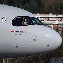 A SAS A320neo in regular livery showing the Star Alliance logo behind the cockpit windows.