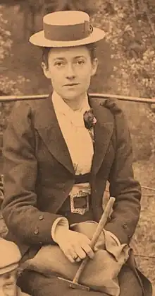 Mary Caroline Hughes seated, holding a geological hammer