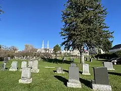 Curé-Adélard-Lamy cemetery, spires of the bell towers of the Catholic church, the village