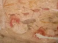 Photograph of drawings of a hunting scene with red animals