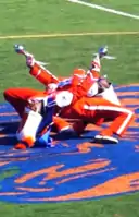 Two drum majors of Savannah State University perform simultaneous backbends.