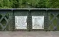 Plaques (one of them vandalized) commemorating the building of an iron and stone bridge on the river Charente (1863)