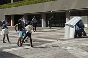 Kids throw fake stones at SeRT officers during an anti-riot demonstration.