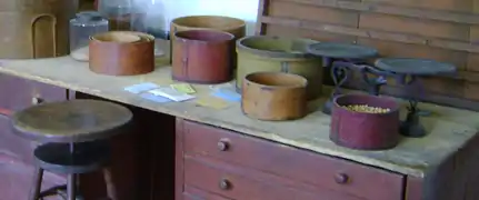 Seed packet envelopes being filled from containers of vegetable seeds at replication shop of Shakertown in Pleasant Hill, Kentucky