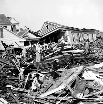 Residents seeking valuables amid piles of wooden debris in the aftermath of the 1900 Galveston hurricane