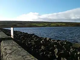 A dam head, with upland beyond the water