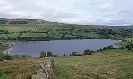 Image of an upland lake surrounded by fields and limestone hills