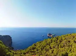 The Cove of Ses Balandres, viewed from the cliff top with the small islands of Ses Margalides