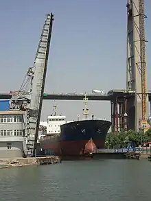 a ship exiting a canal through a raised drawbridge