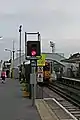 A Merseyrail Class 507 passes a signal, and departs beneath the footbridge, towards West Kirby.