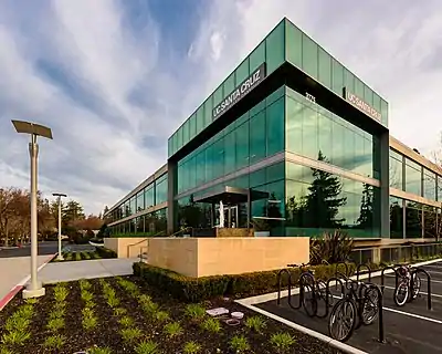 A photo of a modern style three-story building comprising almost entirely of large windows.