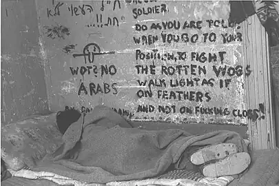 Israeli soldier sleeping during the 1947–1949 Palestine war, Chad is seen on the wall together with inscription "Wot? No Arabs", 1948.