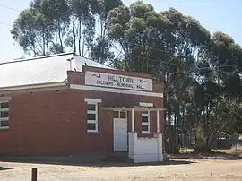 a red brick building with gum trees behind