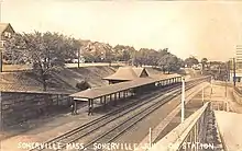 A postcard of a small railway station with a lengthy canopy