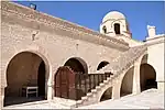 Stairs to the roof, with the Kufic inscription band visible along the top of the wall