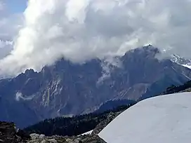 Jagged mountain with its summit hidden in clouds.