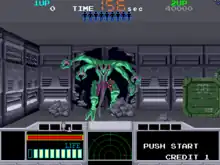 Horizontal rectangle video game screenshot that is a digital representation of a grey room on a space ship. Centered is a green and purple, multi-limbed alien bursting through the wall of a dark corridor.