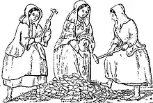 Three women wearing heavy clothing and long bonnets, carrying long hammers, standing around a pile of rocks