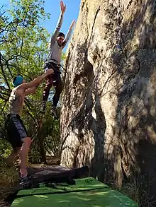 Spotter guiding a falling climber at Roadkill Cafe in Rocklands