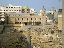 A large church at the edge of an archaeological field.