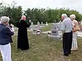 Ukrainian Catholic priest blessing graves, St. John's Cemetery