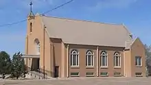 Brick church with four round-topped windows along side