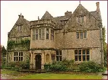 Honey coloured building with prominent porch and triangular fronting to the roof.