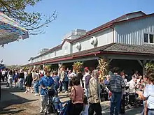 A crowd mingling in front of a building.