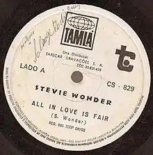 A white vinyl record of the single appears