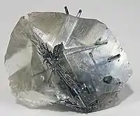 Needles of stibnite within a transparent crystal of calcite (size: 4.5×3.5×1.8 cm)