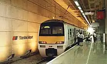 Train parked on the platform. There are people on the platform