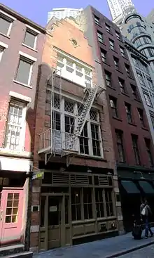 57 Stone Street, built in 1903 in the Dutch Colonial Revival style, with a brick facade and a stepped gable on the roof