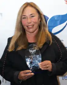 A candid shot of Susan Seidelman holding a lifetime achievement award from Mystic Film Festival