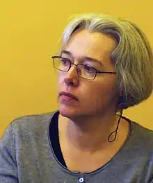 Photograph of a woman with short grey hair and glasses.