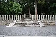 Torii and concrete fence among trees.