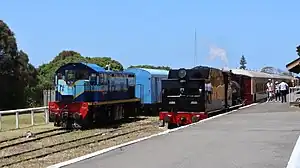 T251 gets ready to haul the 'Swan Bay Express' while 1107 sits parked in a siding with the Q train