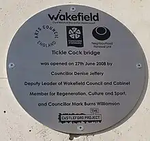 Oval metal plaque fixed to a wall.