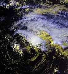 Satellite image of a weak tropical cyclone. The storm has an exposed center situated just south of deep convection. Cirrus clouds extend to the northeast of this area; no land is visible in the image.