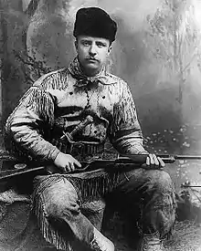 Theodore Roosevelt in 1885 with his highly decorated deer-skin hunting suit, and Tiffany-carved hunting knife and rifle