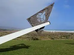 The plaque below the symbol reads - The Prime Minister, the Rt Hon. N E Kirk, unveiled this symbol of co-operation between New Zealand Steel Limited and the Maori people of Taharoa to mark the official opening of the Taharoa ironsands operation on 24 November 1973.