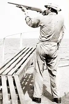 Image 37A merchant seaman aboard a fleet oil tanker practices target shooting with a Remington 870 12 gauge shotgun as part of training to repel pirates in the Strait of Malacca, 1984 (from Piracy)