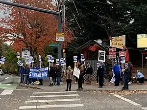 Photograph of people standing on a street corner, holding signs: "When teachers win, students win," "PAT on strike," "On strike for our students," "Ready to strike"