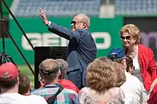 Photograph of Ted Lerner standing and waving to a crowd