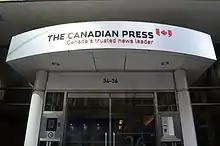 Exterior of an office building including the front door with The Canadian Press logo above the entrance