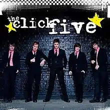 The cover consists of the band wearing pink dress shirts and black suits, standing in front of a black brick wall. The band's logo appears above them.