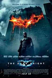 In the background, a building burns in the outline of a bat symbol. In front of the building, Batman looms. Above reads the tagline: "Welcome to a world without rules." Below is the film's logo and the credits.