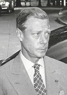 Head and shoulders view, in black and white, of Edward in a grey suit, white shirt, and starkly tartaned tie