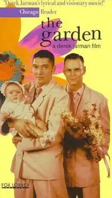 a male couple in suits on a colorful background depicting a flower. The one on the left holds a baby and the one on the right holds a bouquet.