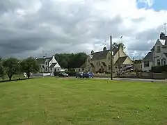 View of green and houses in the village of Ae