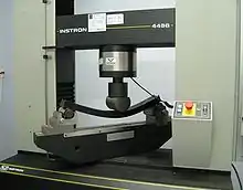 Test fixture on universal testing machine for three-point flex test